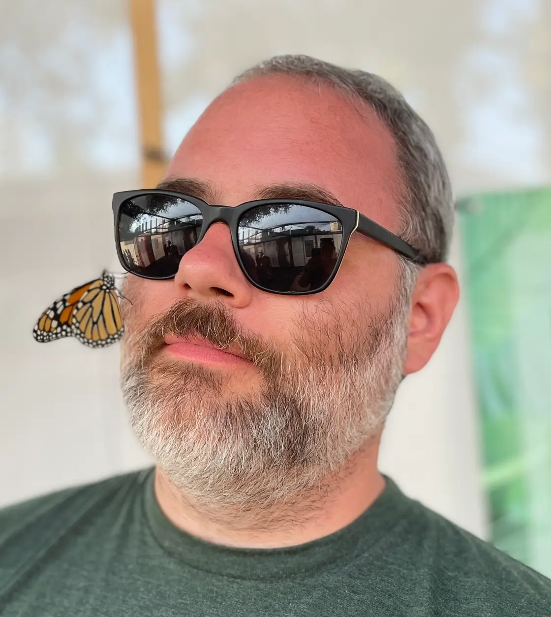 Me in sunglasses, with a monarch butterfly on my cheek